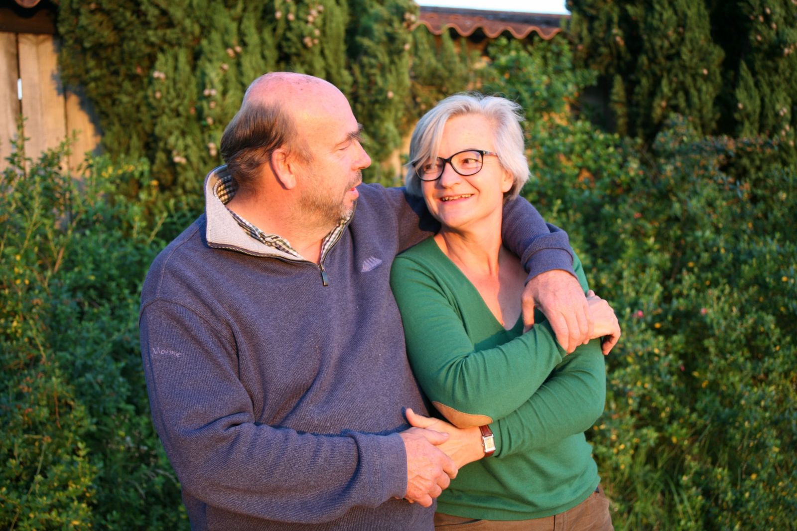 Couple de vignerons heureux , bras dessus-bras dessous.