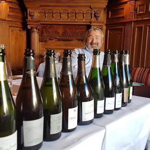 Bouteilles de champagne alignées sur une nappe blanche.